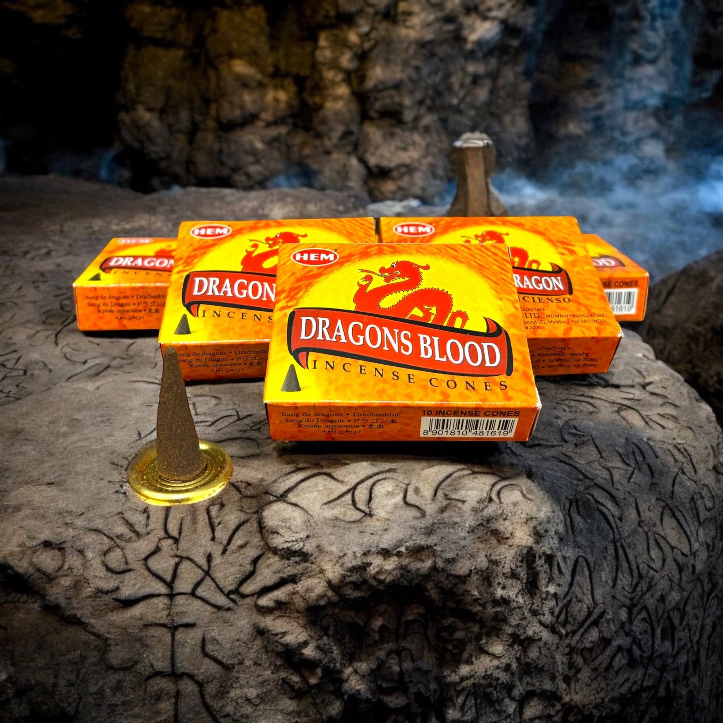 Neatos Elements Dragons Blood Incense Cones in orange packaging with red dragon graphic. One cone is lit on a golden holder.