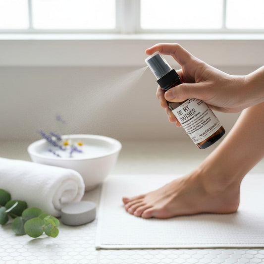 Neatos Elements Oh My Tootsies! Magnesium Foot Spray in a 2 oz amber glass bottle with a black spray top. Scented with lavender & chamomile.