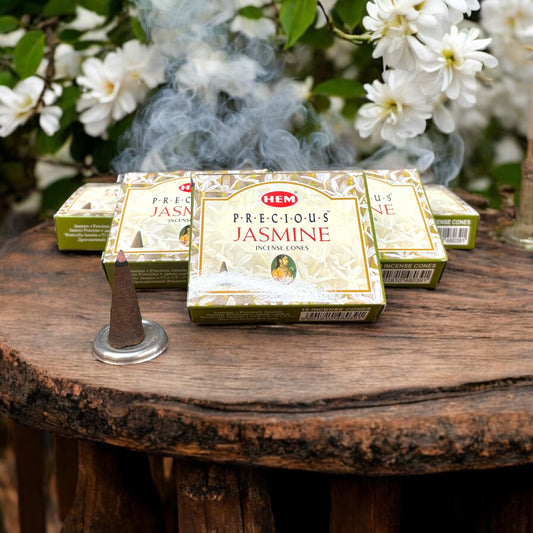 Neatos Elements Precious Jasmine incense cones, known for their sweet floral scent, displayed on a wooden table with smoke rising.