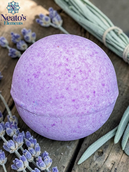 Neatos Elements Goddess of the Night Bath Bomb, a round, light purple bath bomb with speckles, surrounded by lavender sprigs and sage on a wooden surface.