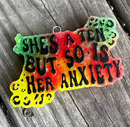 Neatos Elements Paradise Gone Wild car freshie with black text reading "SHE'S A TEN BUT SO IS HER ANXIETY" on a colorful gradient background.