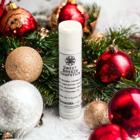 Neatos Elements Sweet Breeze chapstick in a festive holiday arrangement with ornaments and greenery.