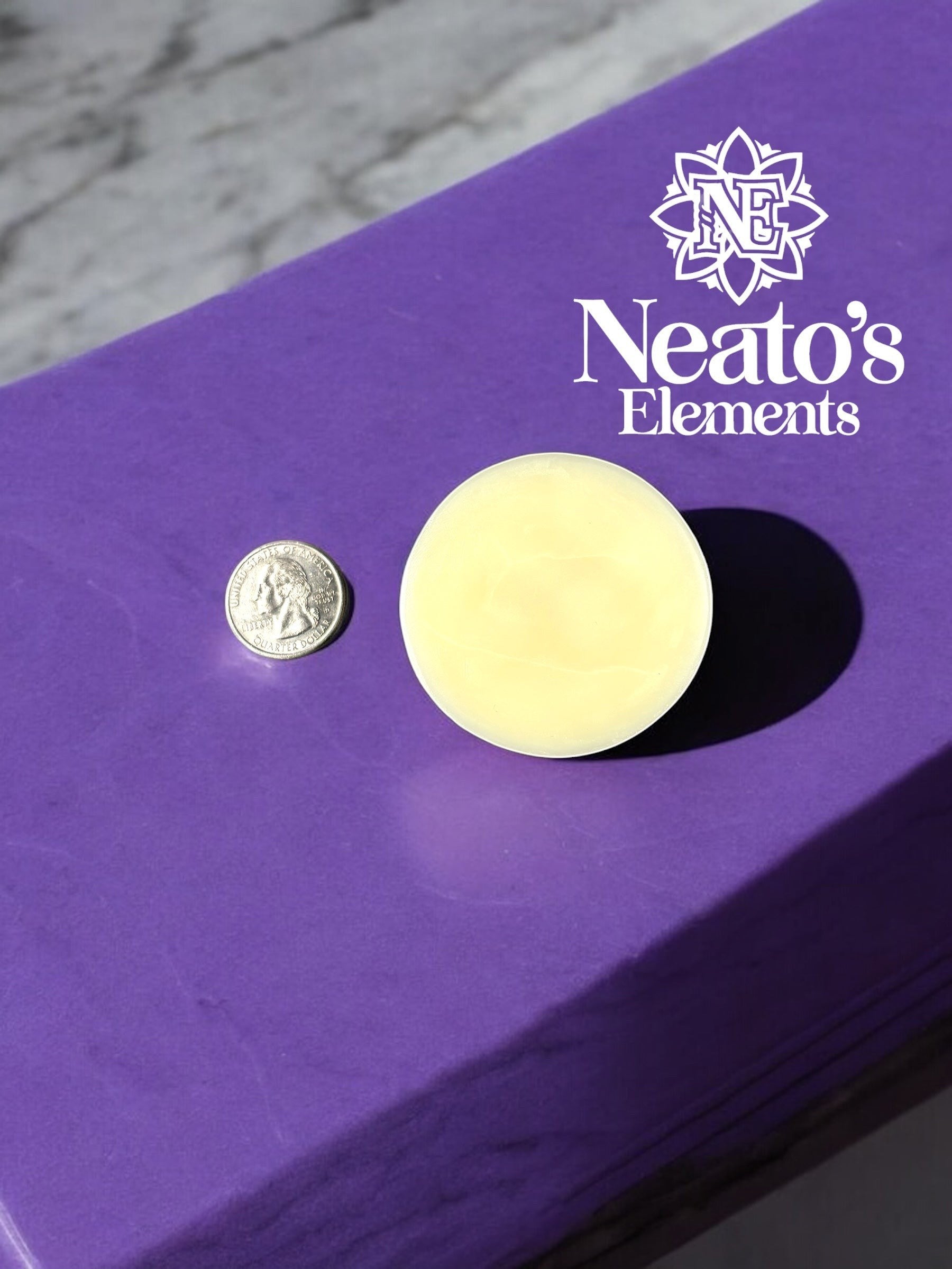 Neato's Elements Citrus Blossom Lotion Bar, a solid yellow bar next to a quarter for size comparison, on a purple surface.