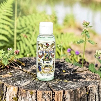 Neatos Elements Florida Water Cologne 2 oz bottle on a mossy tree stump with ferns and a pond in the background.