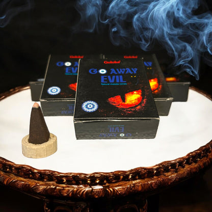 Neatos Elements Go Away Evil incense cones with a burning cone and blue smoke. Natural masala cones for spiritual rituals.