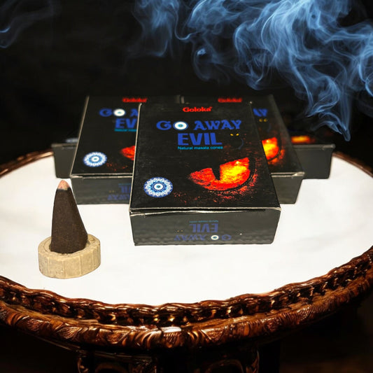 Neatos Elements Go Away Evil incense cones with a burning cone and blue smoke. Natural masala cones for spiritual rituals.