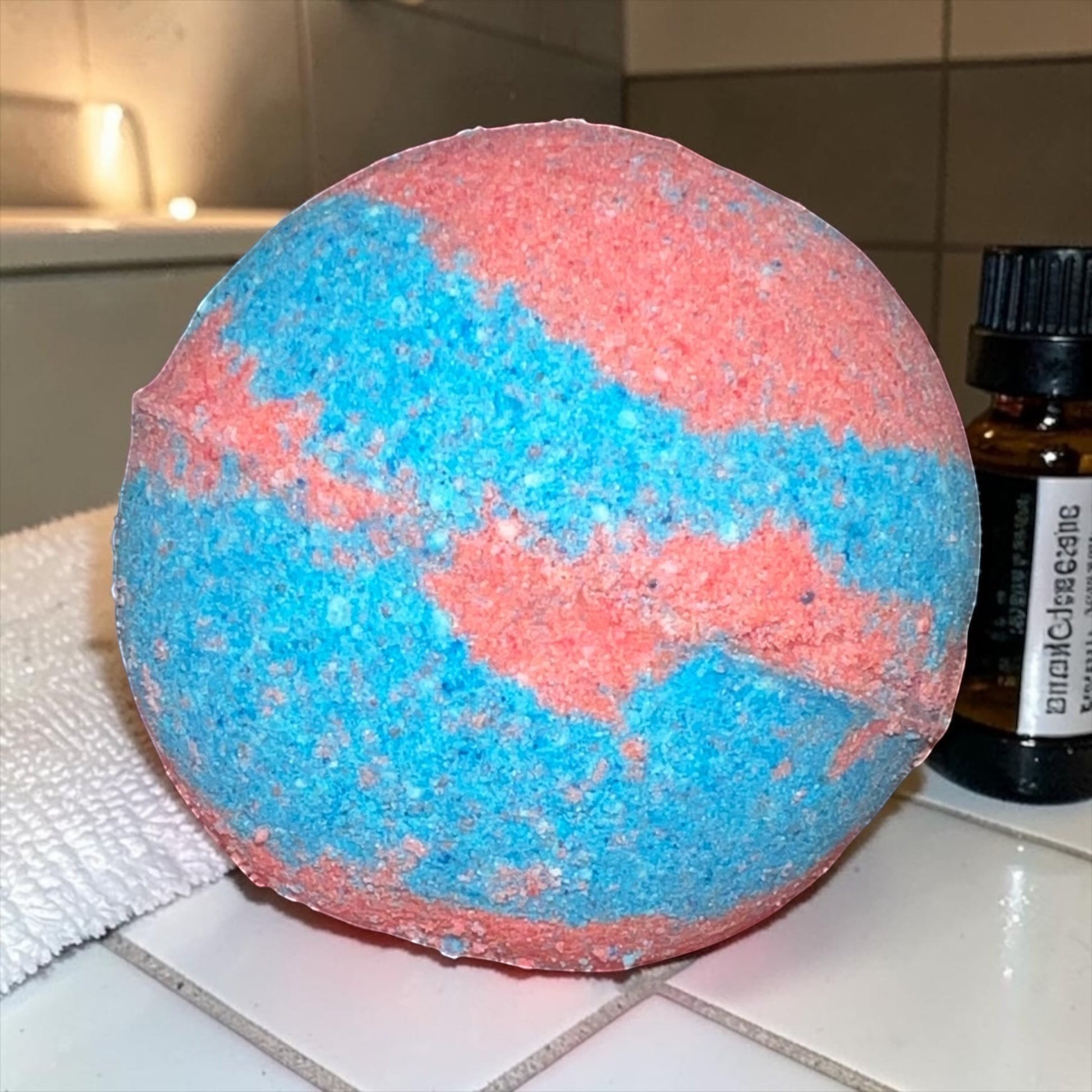 Neatos Elements Heartbreaker bath bomb, swirled blue and pink, with hidden crystal.