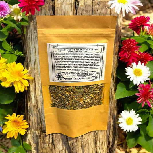 Neatos Elements Lemon Light & Warmth Imbolc Inspired Tea Blend loose leaf tea in a brown paper pouch, surrounded by colorful flowers.