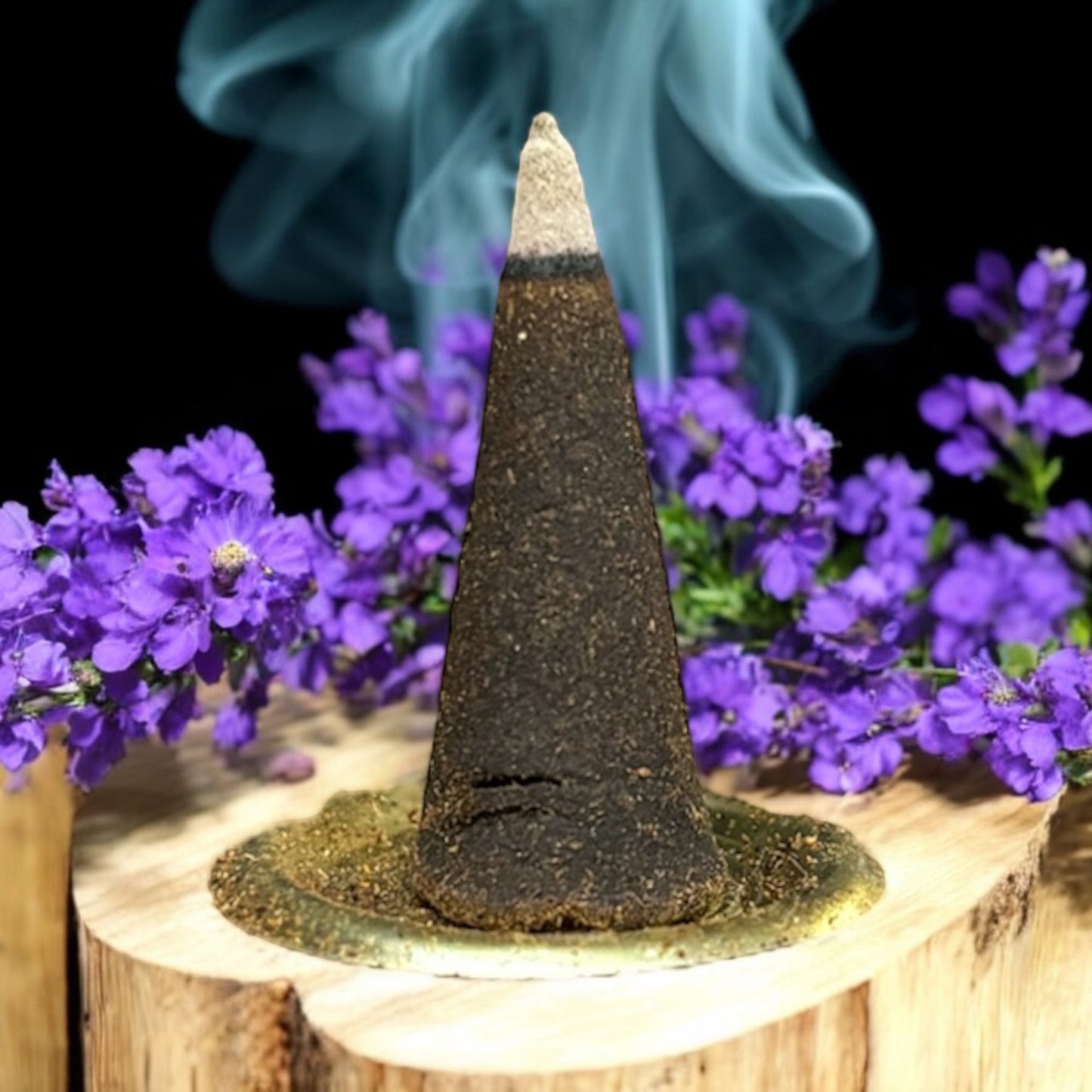 Neatos Elements Precious Lavender incense cone burning with blue smoke, surrounded by purple flowers on a wooden base.