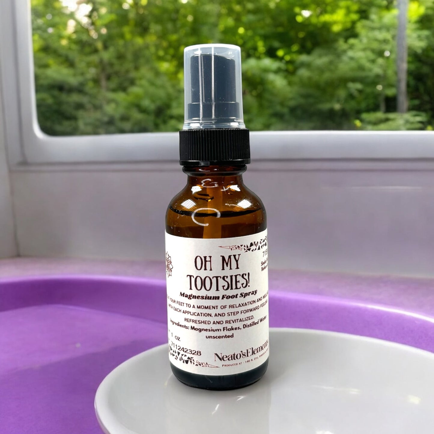 Neatos Elements Oh My Tootsies! Magnesium Foot Spray in a 1 oz amber glass bottle with a black spray top. Unscented.