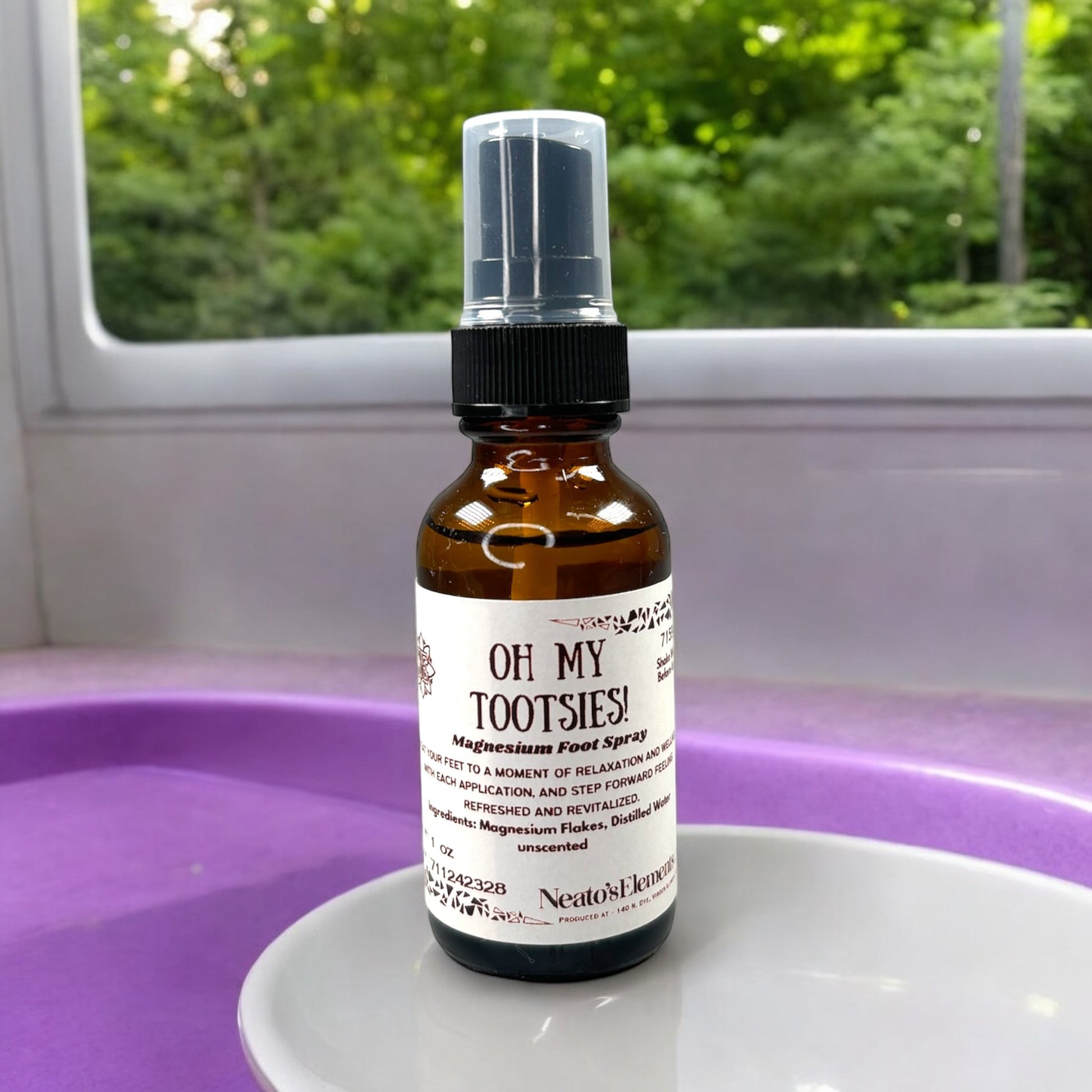 Neatos Elements Oh My Tootsies! Magnesium Foot Spray in a 1 oz amber glass bottle with a black spray top. Unscented.