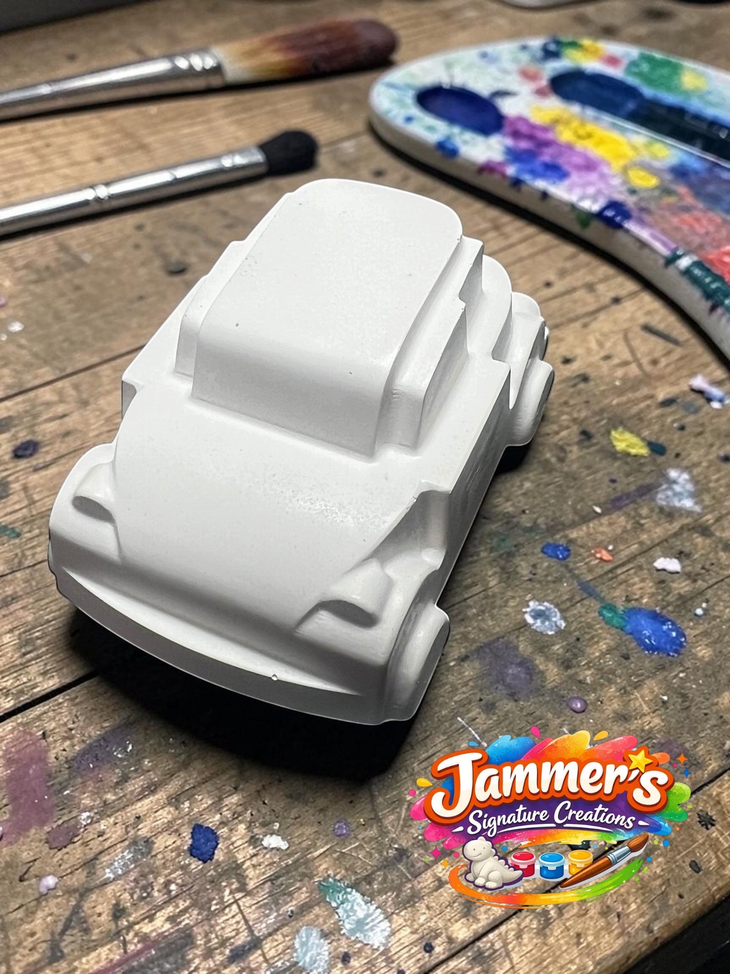 Neatos Elements white plaster mini motor figurine, ready to be painted. Features a simple, rounded design with visible wheels and a flat top.