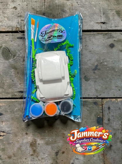 Neatos Elements Mini Motors painting kit with white plaster car, 3 paint pots (blue, orange, black), and 2 brushes.