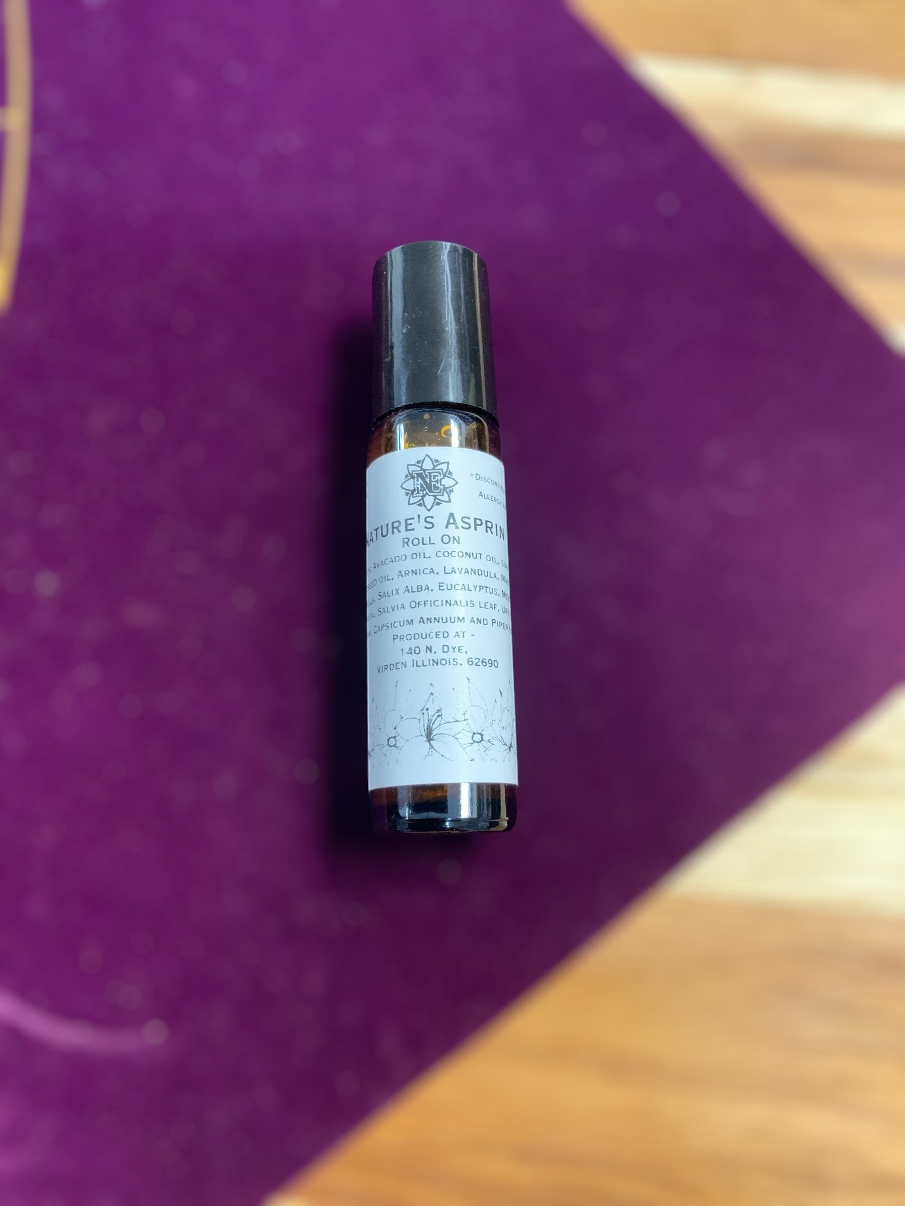 Neatos Elements Nature's Aspirin Roll On with herbal blend for ease and relaxation. Amber glass bottle with black cap.