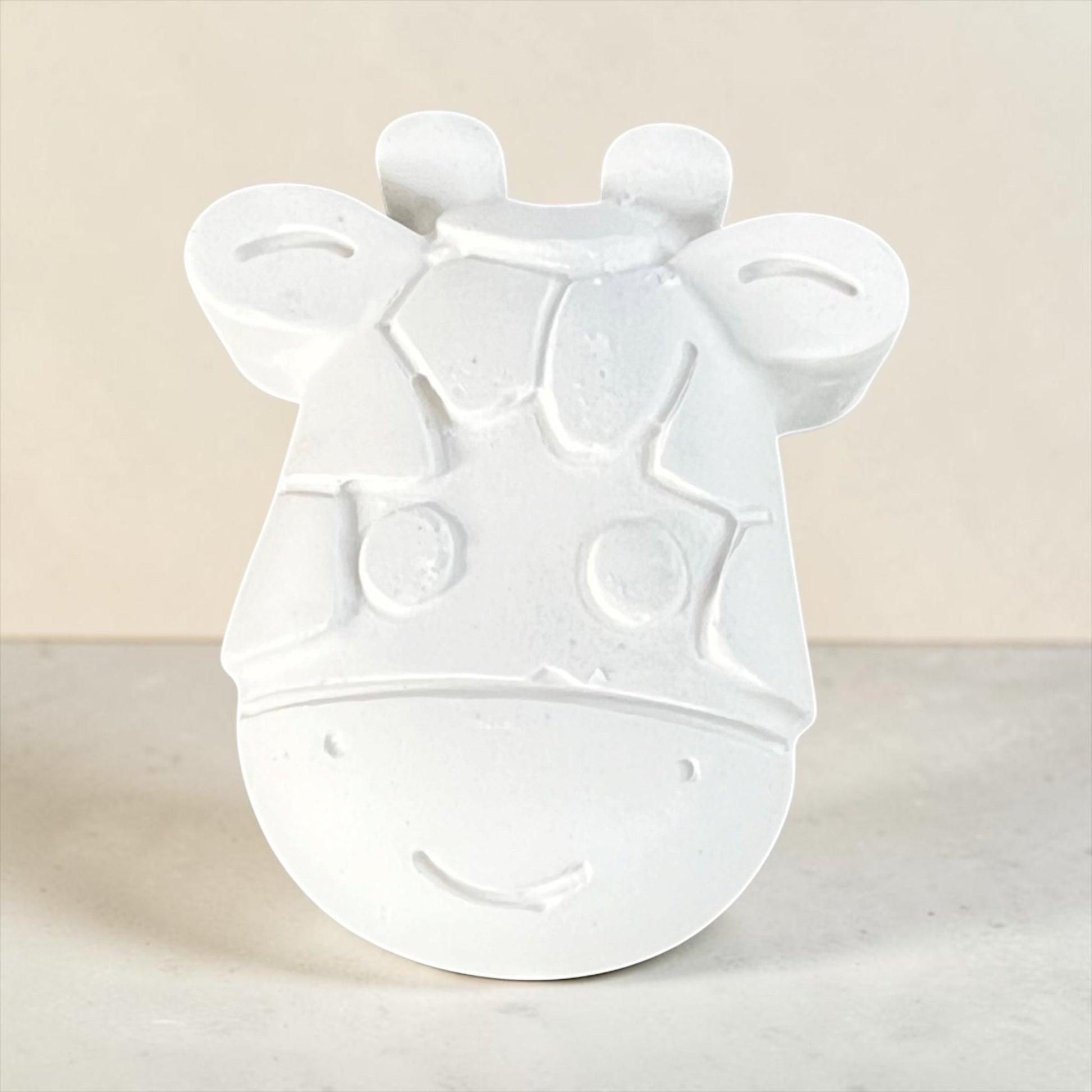 Neatos Elements white plaster giraffe head, ready to paint, with a smiling face and textured pattern.