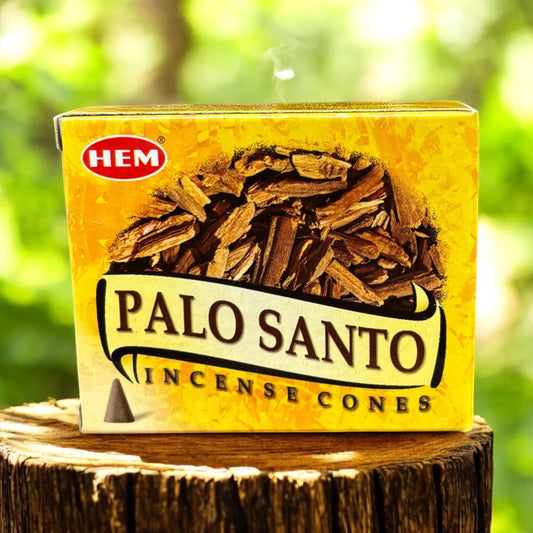 Neatos Elements Palo Santo Incense Cones box with a pile of wood chips on a rustic wooden stump.