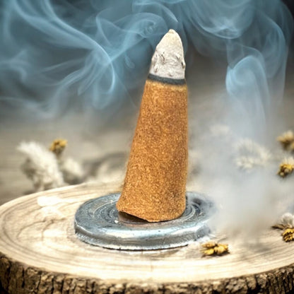 Neatos Elements Precious Patchouli incense cone burning, releasing aromatic smoke. Earthy, grounding scent.