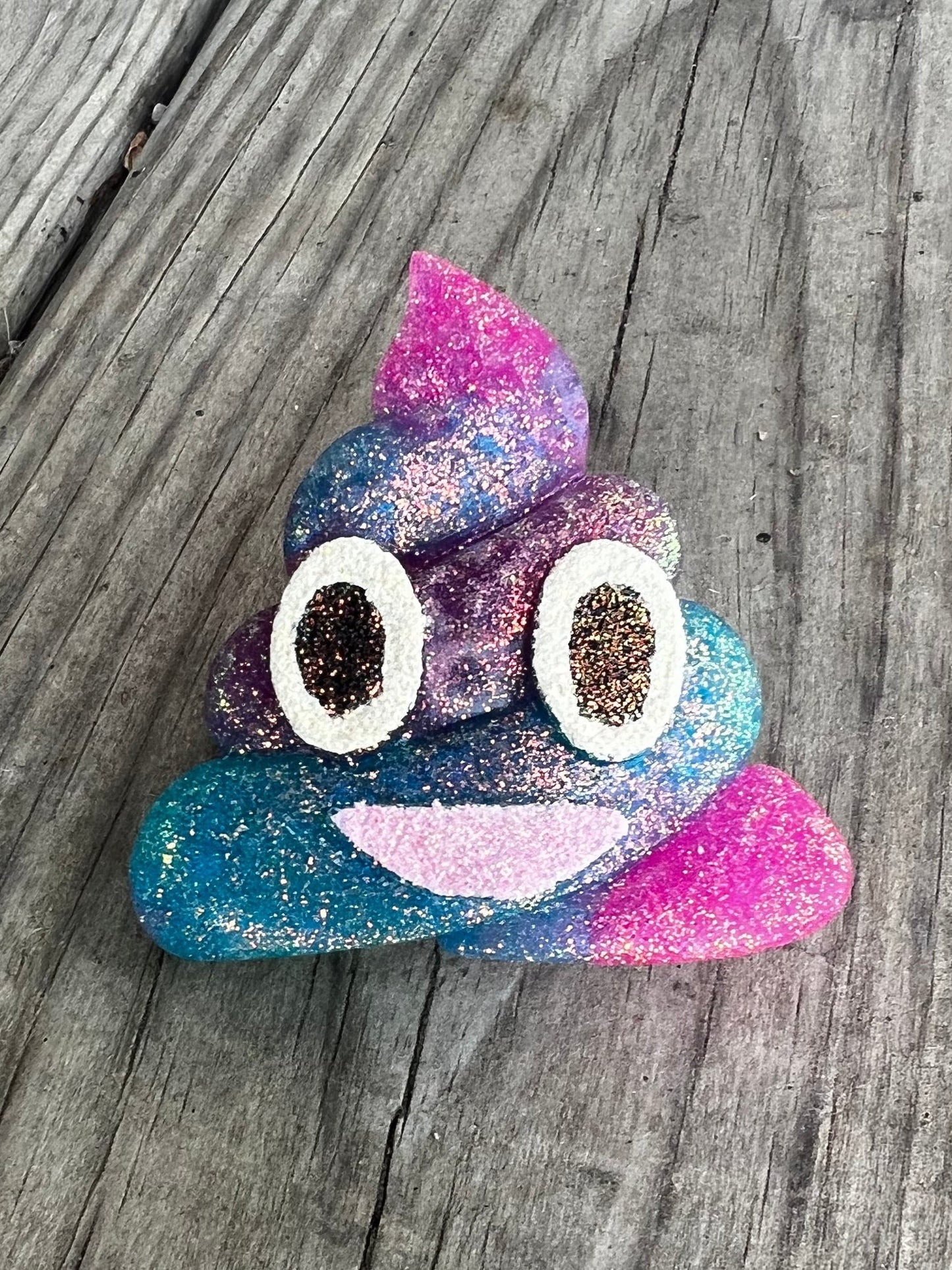 Neatos Elements poop emoji car vent freshie, glittery blue and pink aroma beads, white eyes with brown glitter.