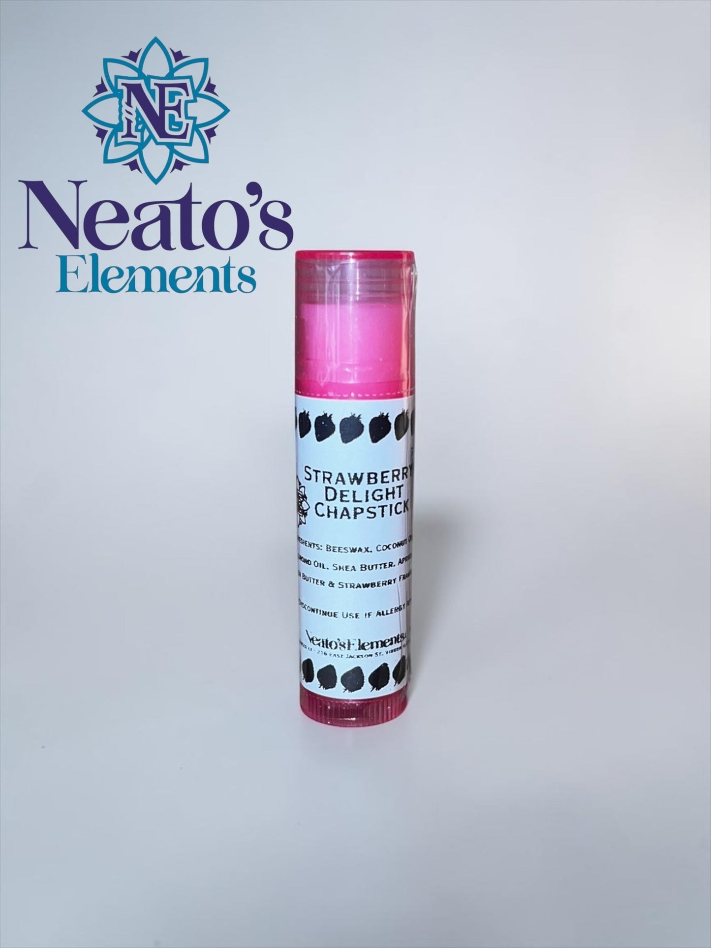 Neato's Elements Strawberry Delight Chapstick, a pink lip balm with strawberry illustrations on the label, made with beeswax, coconut oil, and shea butter.