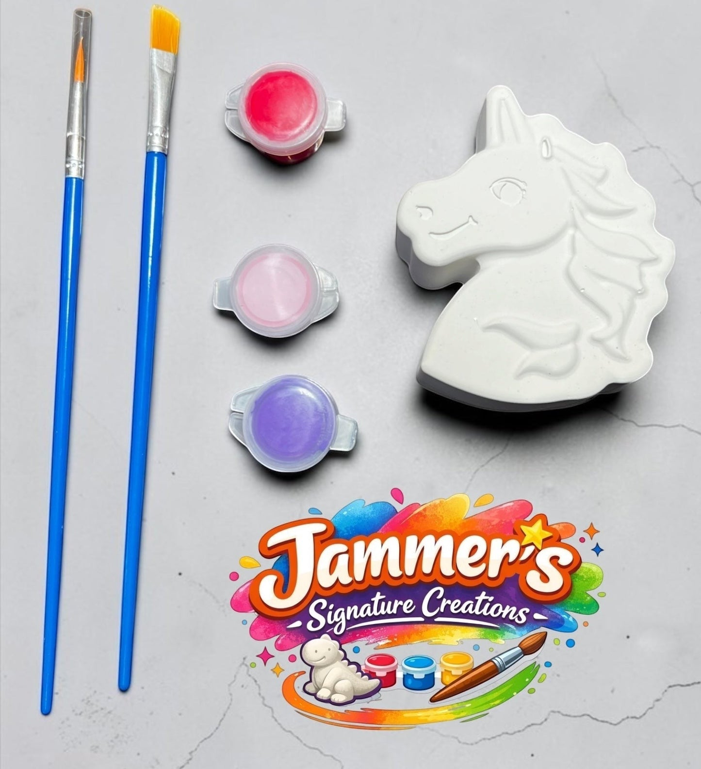 Neatos Elements Enchanted Unicorn paint kit with white plaster unicorn figurine, 3 paint pots (red, pink, purple), and 2 paint brushes.