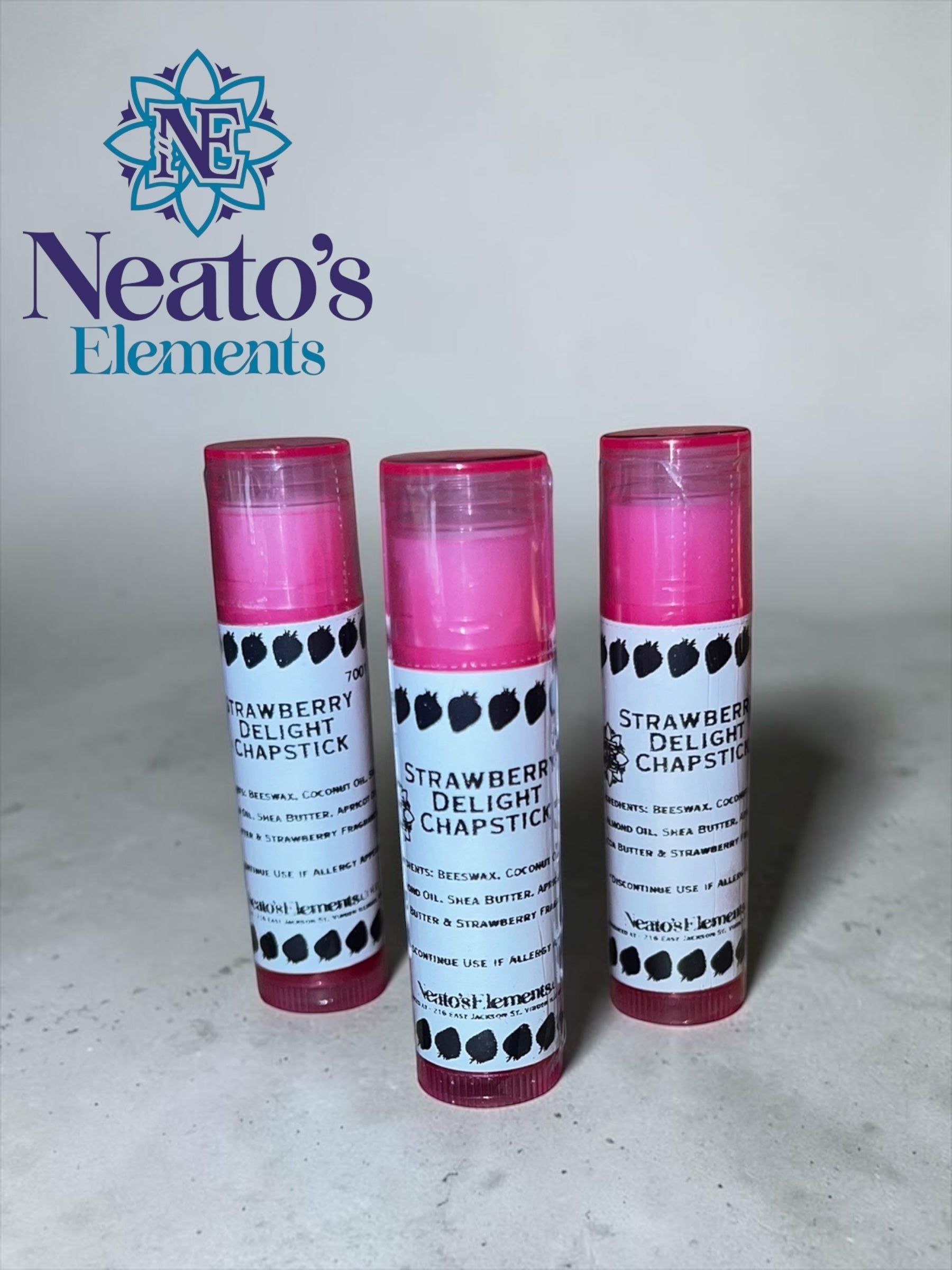 Neato's Elements Strawberry Delight Chapstick, handmade with beeswax, coconut oil, almond oil, shea butter, apricot oil, cocoa butter, and strawberry flavoring for soft, hydrated lips.
